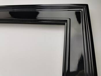 Detal narożnika eleganckiego lustra dekoracyjnego w czarnej ramie