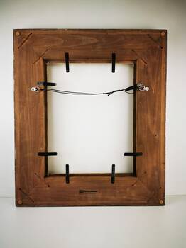 Zdjęcie poglądowe tyłu ramy do obrazu z pracowni – sprężynujące blaszki, linka do zawieszenia i starannie wykończona oprawa.